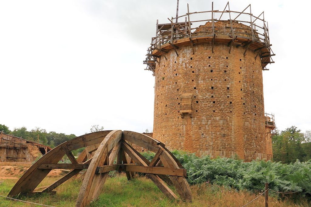 Picture of a brown stone medieval tower under construction.